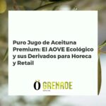 Botella de AOVE ecológico premium vertiendo sobre un plato gourmet, con fondo de olivar y cocina